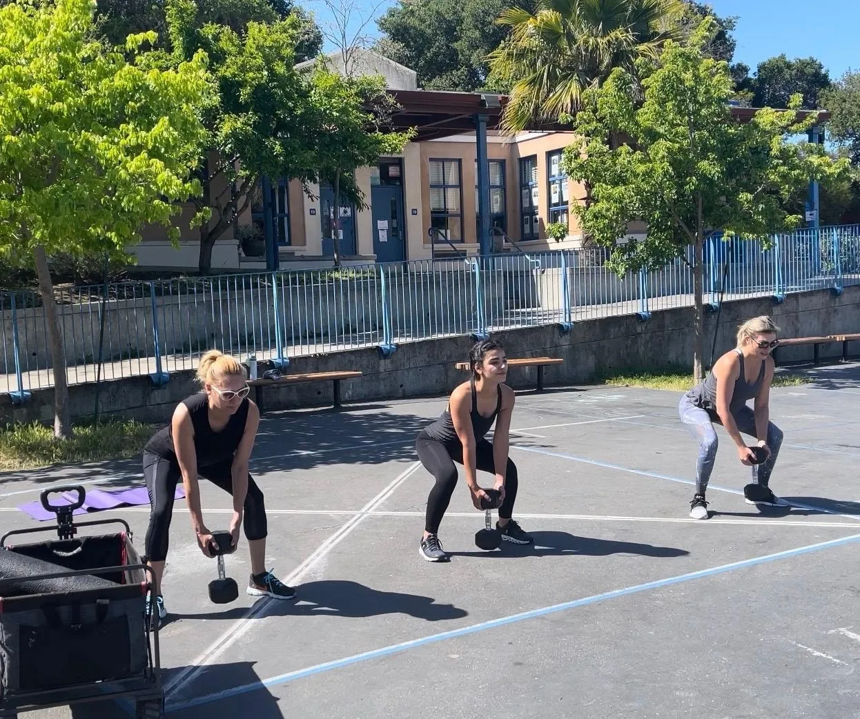 Coaching a group through dumbbell deadlifts on the court
